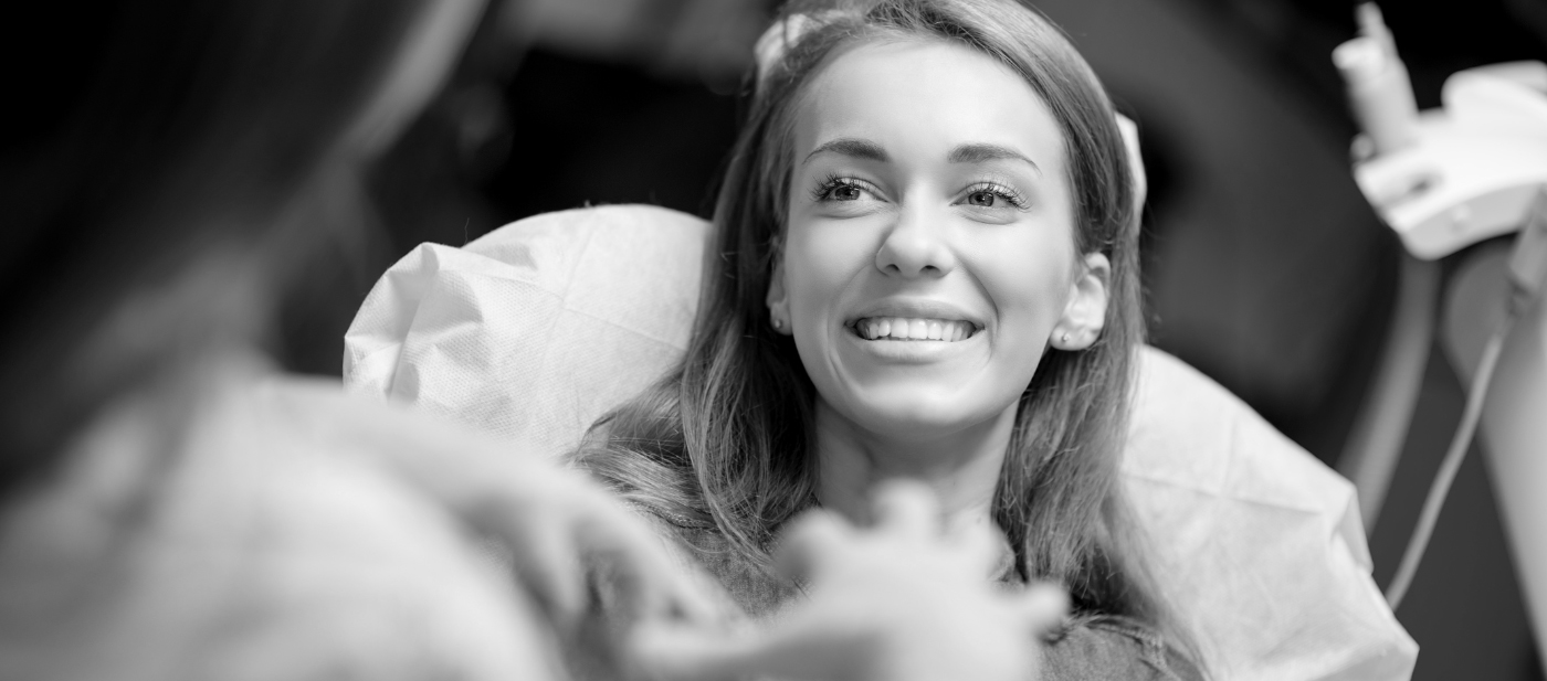 Woman smiling while receiving dental services