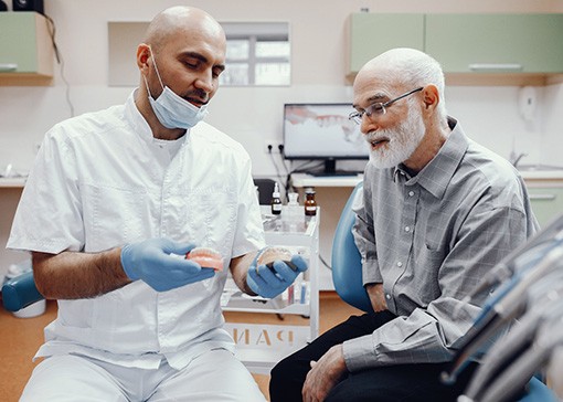 A dentist talking to his patient about denture safety